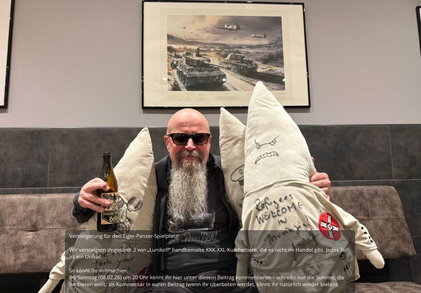 Der rechtsextreme Musiker "Lunikoff" sitzt auf einer Couch mit drei handsignierten "Ku-Klux-Klan-Kuscheltieren". 