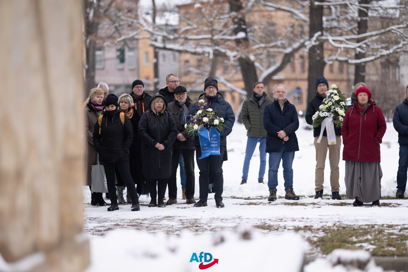 Thomas Benninghaus (in der Mitte, weißes Blumengesteck mit blauem Band) legt mit Mitgliedern des AfD-Kreisverbandes am 27.01.2026 am Mahnmal für die Opfer des Faschismus in Rudolstadt Kränze nieder. 