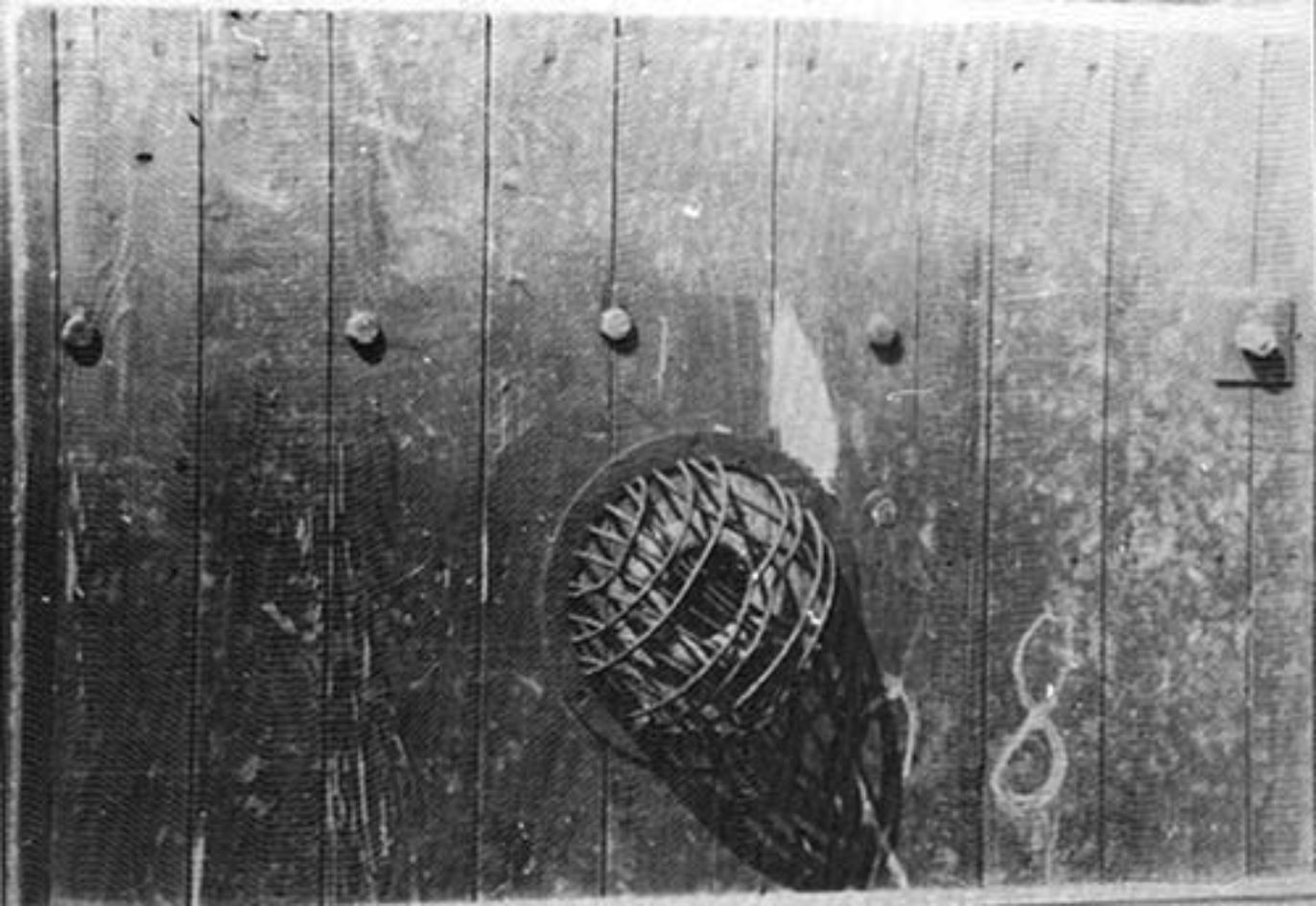 Detail der Innenseite einer der Türen, die 1945 noch gefunden werden konnten. Das Guckloch mit 8mm Doppelglas wurde durch eine Metallkonstruktion geschützt, um zu verhindern, dass die Opfer im Todeskampf das Glas einschlagen.