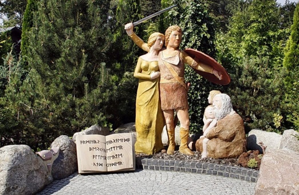 Naive Darstellung von Arminius und Thusnelda sowie einem Greis und zwei Kindern in Form von Holzfiguren.