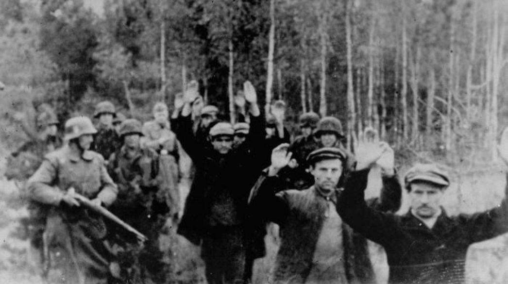 SS-Truppen führen Pol:innen in einen Wald in der Nähe von Witaniow, wo sie erschossen wurden. Das Foto stammt wahrscheinlich aus dem Oktober oder November 1939.