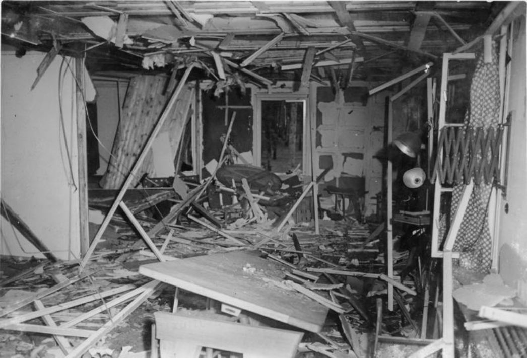 Der Besprechungsraum in einer der Baracken der "Wolfsschanze" nach dem Attentat am 20. Juli 1944. Möbel, Wände und Decke sind deutlich von der Wucht der Explosion gezeichnet, überall liegt Holz und sperriges Material. 