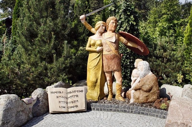 Naive Darstellung von Arminius und Thusnelda sowie einem Greis und zwei Kindern in Form von Holzfiguren.